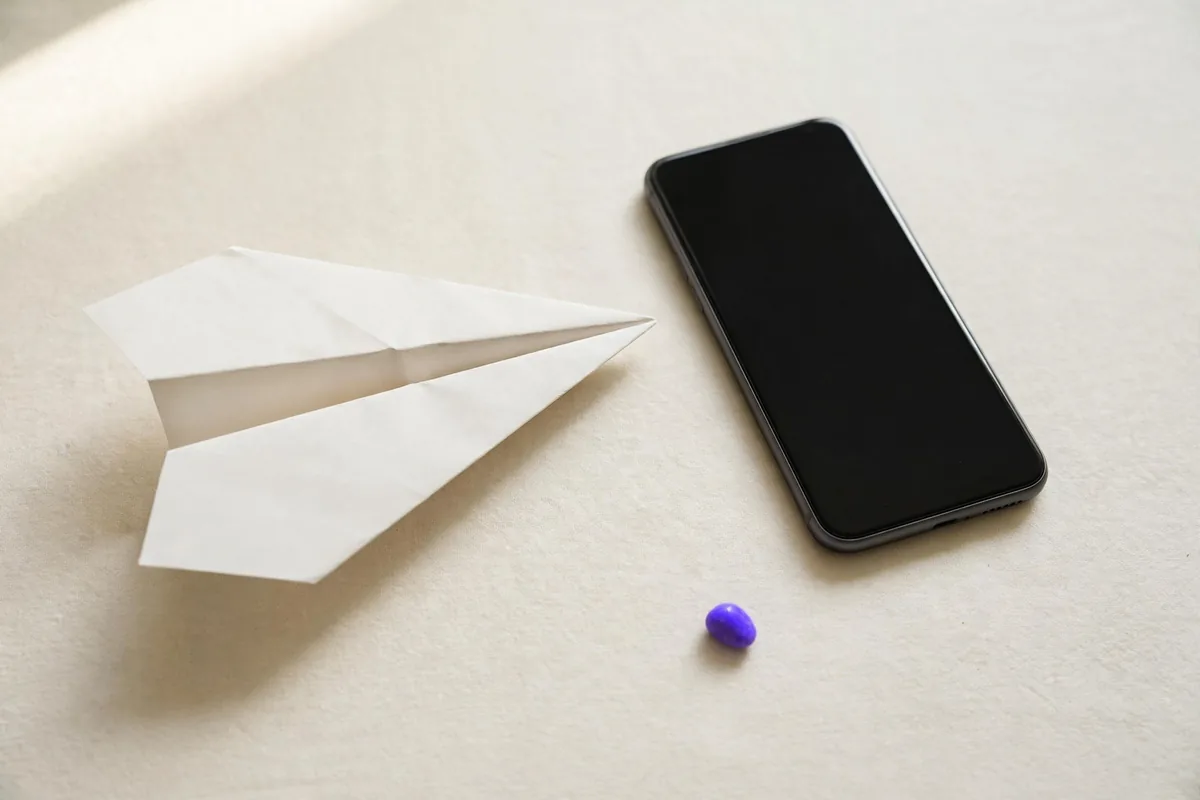 A paper plane next to a phone